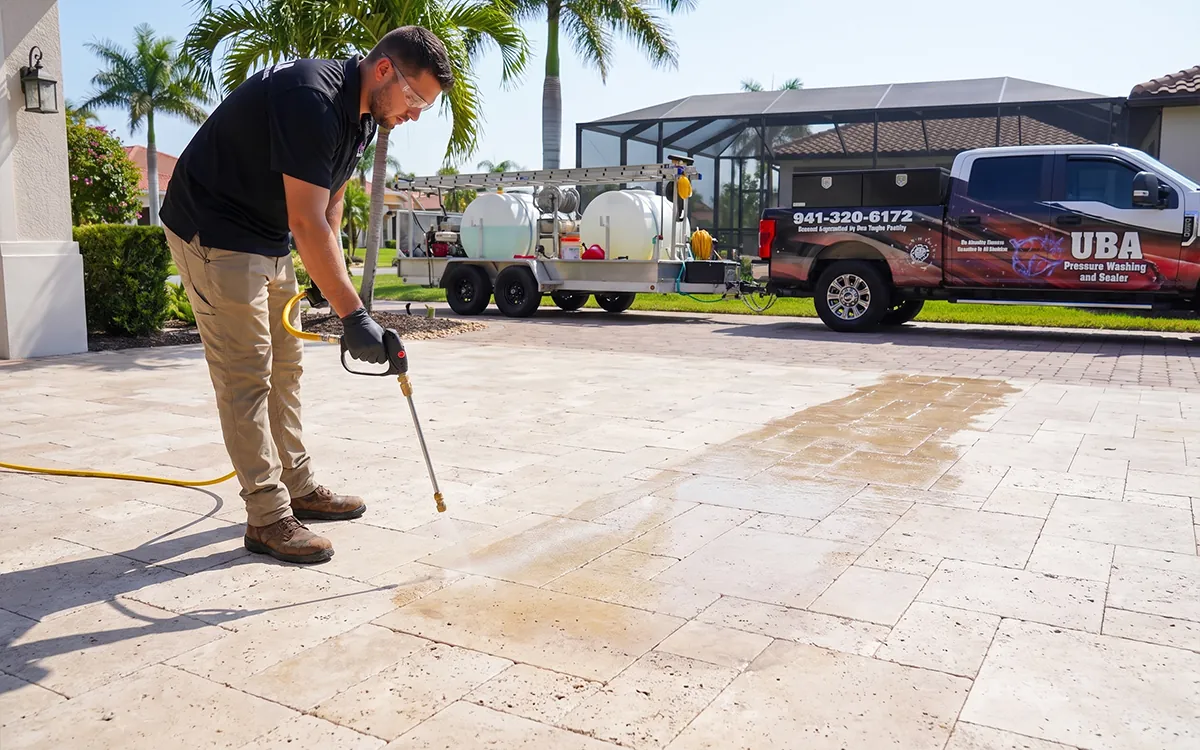 UBA crew lead assessing a Sarasota travertine paver pool deck with a homeowner