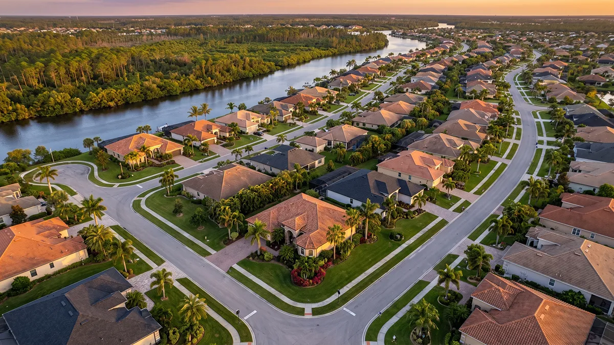 Aerial view of a Port Charlotte canal neighborhood with cleaned roofs and pool cages
