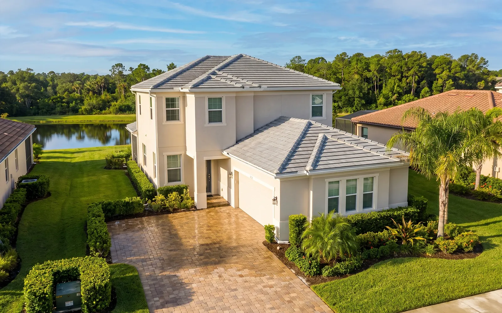 Pressure washing Lakewood Ranch home with clean tile roof, washed stucco and sealed paver driveway