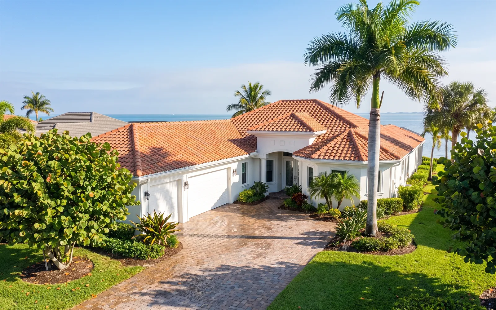 Pressure washing Venice FL home with clean tile roof, washed stucco and sealed paver driveway
